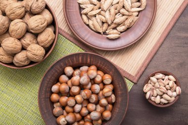 Kahverengi kil tabaklarda çeşitli fındıklar var. Ceviz, fındık, badem, şam fıstığı ve fındık kıracağı.