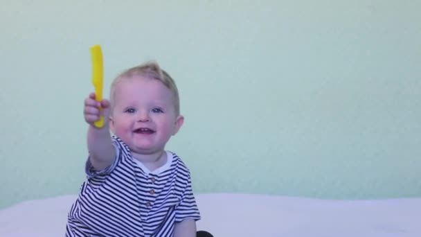 Portrait of a cute smiling baby who is combing his hair with a special brush. The concept of baby hygiene, childcare and health care, skills, independence — Vídeo de Stock