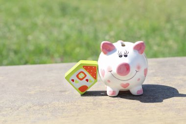 Ahşap bir ev ve kumbara modeli. Konsept yatırım ipoteği finansmanı ve konut kredisi yeniden finanse edilmesi için para birikimi. Kopya alanı - emlak, tasarruf, inşaat kavramı
