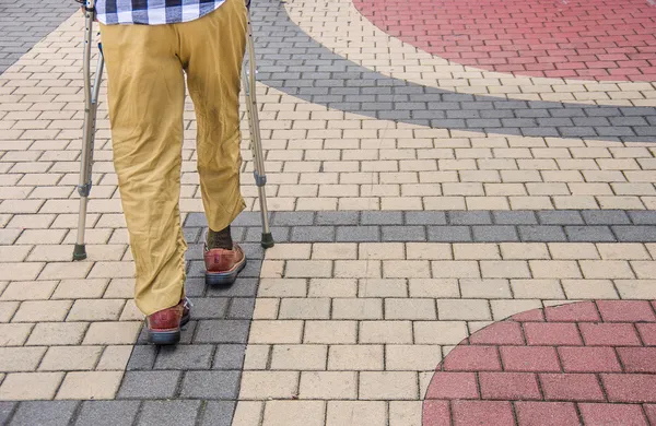 Hombre caminando con muletas — Foto de Stock