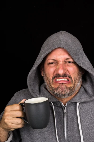 Portrait of disgusted man drinking a cup of coffee — Stock Photo, Image