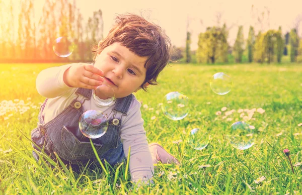 Dítě hraje s mýdlové bubliny — Stock fotografie
