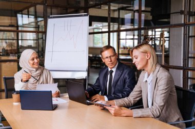 Stratejik pazarlama planı için ofiste çok ırklı iş adamları toplanıyor. Ofis çalışanları, girişimciler ve çok uluslu bir şirkette çalışan şirket çalışanları.