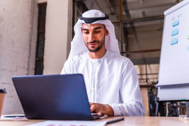 Arap işadamı Dubai 'deki uluslararası bir şirkette geleneksel emirlik kandurası giyiyor.