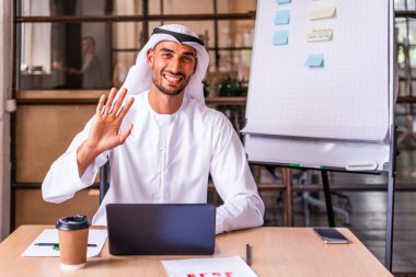 Arap işadamı Dubai 'deki uluslararası bir şirkette geleneksel emirlik kandurası giyiyor.