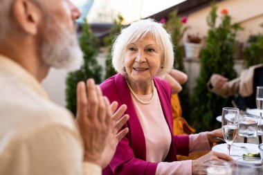 Çok ırklı bir grup insanın çatıda yemek yediğini gösteren görüntüler. Aile ve arkadaşlar evde bir araya gelir.