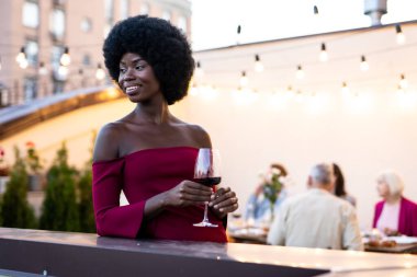 Çok ırklı bir grup insanın çatıda yemek yediğini gösteren görüntüler. Aile ve arkadaşlar evde bir araya gelir.