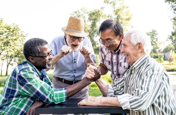 Grupa Starszych Przyjaciół Grająca Siłowanie Się Rękę Parku Koncepcje Stylu — Zdjęcie stockowe