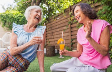 Güzel, son sınıf kızları bahçede dinleniyor. 3 olgun bayan huzurlu bir bahçede dinleniyor.
