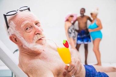 Mutlu son sınıf öğrencisi yüzme havuzunda parti veriyor. Aktif yaşlı erkek yazın güneşleniyor ve özel bir havuzda dinleniyor.