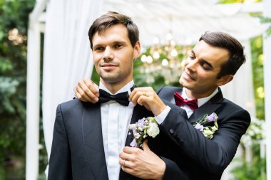 Homosexual couple celebrating their own wedding - LBGT couple at wedding ceremony, concepts about inclusiveness, LGBTQ community and social equity clipart