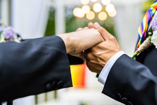 Гомосексуальная пара празднует собственную свадьбу - LBGT пара на свадебной церемонии, концепции о инклюзивности, ЛГБТК сообщество и социальный равенство
