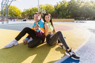 Açık havada kaynaşan ve şehir kaykay parkında toplanan havalı gençlerden oluşan çok kültürlü bir grup.