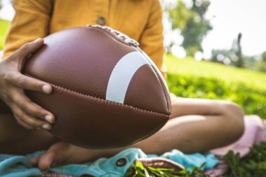 Güzel mutlu Afro-Amerikan aile parkta kaynaşıyor siyahi aile dışarıda eğleniyor, aileler ve çocuklar futbol oynuyor.