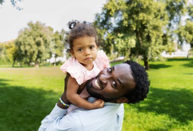 Güzel, mutlu, Afro-Amerikan ailesi parkta kaynaşıyor.