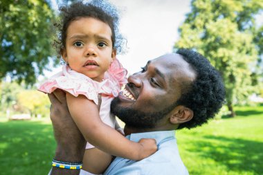 Güzel, mutlu, Afro-Amerikan ailesi parkta kaynaşıyor.