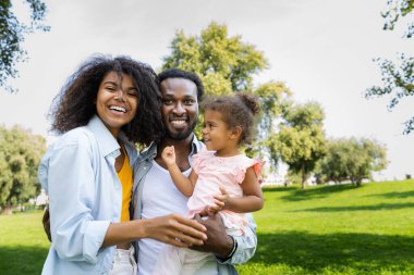 Güzel, mutlu, Afro-Amerikan ailesi parkta kaynaşıyor.