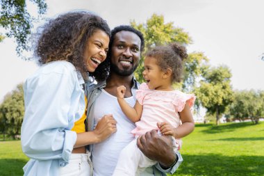 Güzel, mutlu, Afro-Amerikan ailesi parkta kaynaşıyor.