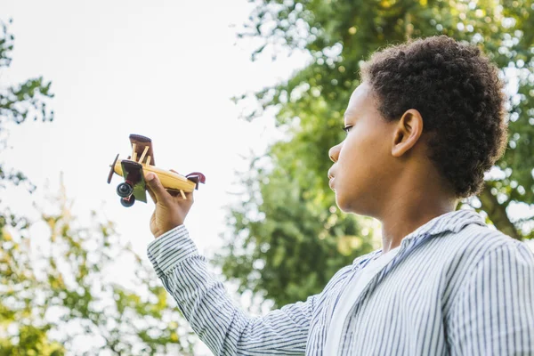 公園で美しい幸せなアフリカ系アメリカ人の家族の絆 屋外で楽しい時間を過ごしている黒人家族 飛行機のおもちゃで遊ぶかわいい若い男の子 — ストック写真