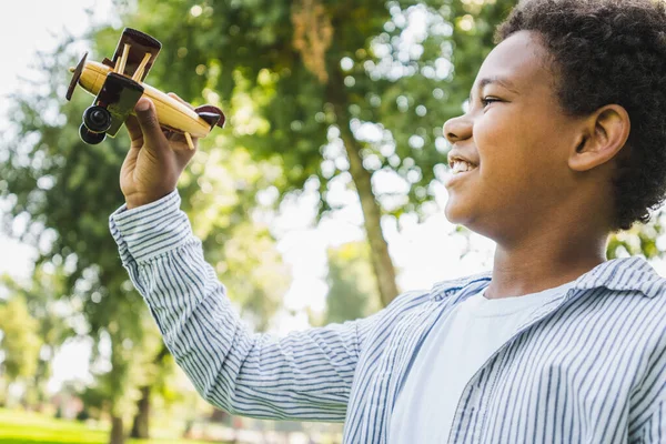 公園で美しい幸せなアフリカ系アメリカ人の家族の絆 屋外で楽しい時間を過ごしている黒人家族 飛行機のおもちゃで遊ぶかわいい若い男の子 — ストック写真