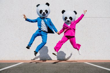 Dev panda kafalı ve renkli takım elbiseli bir çiftin hikaye anlatımı. Kadın ve erkek otoparkta parti yapıyor..