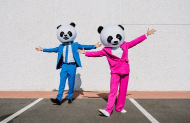 Dev panda kafalı ve renkli takım elbiseli bir çiftin hikaye anlatımı. Kadın ve erkek otoparkta parti yapıyor..