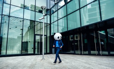 Dev bir panda kafası takan bir iş adamı görüntüsü.