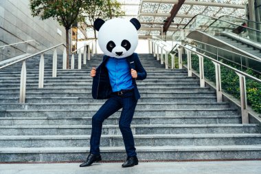 Dev bir panda kafası takan bir iş adamı görüntüsü.