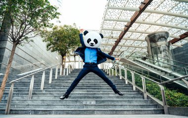 Dev bir panda kafası takan bir iş adamı görüntüsü.