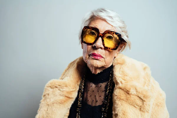 一个美丽而优雅的影响深远的老妇人的形象 穿着时髦衣服在演播室摆出一副很酷的奶奶的样子 — 图库照片