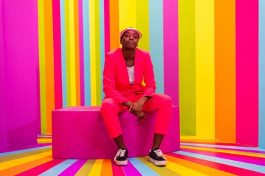 Güzel Afrikalı Amerikalı genç bayan dansçı gökkuşağı locasında eğleniyor - havalı ve şık afro-yetişkin kadın portresi çok renkli arka planda, nüfuz edici bir selfie odasında sosyal ağlar için içerik yaratıyor