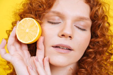 Stüdyoda güzellik ve vücut pozitifliği için poz veren kıvırcık saçlı güzel bir genç kadın. Sağlıklı yaşam tarzı ve yiyecek kavramı