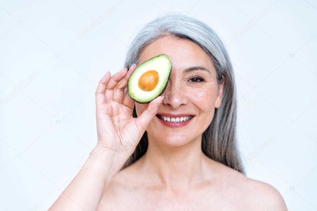 Image of a senior woman posing in studio for a body positive concepts photoshooting. old model showing fruits and healthy food good for the skin care therapy