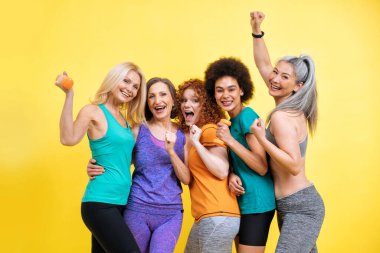 Farklı vücut, yaş ve ırk yapısına sahip bir grup kadın spor yapıyor. Spor kıyafetleri giyen kadın modeller spor salonunda eğleniyor. Vücut pozitifliği, kendini kabullenme ve yaşam tarzı kavramları