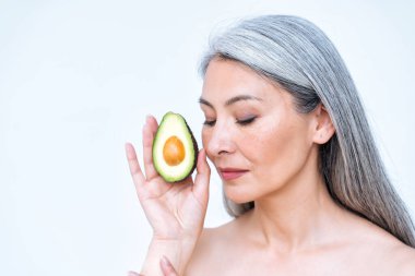 Vücut pozitifliği için stüdyoda poz veren son sınıf bir kadının fotoğrafı. Eski model meyve ve sağlıklı yiyecekler cilt bakımı için iyi gelir.