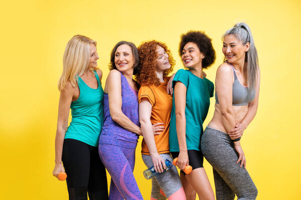 Group of women with different body, age, and ethnicity making sport. Female models wearing sport outfits having fun at the gym. Concept about body positivity, self acceptance and lifestyle