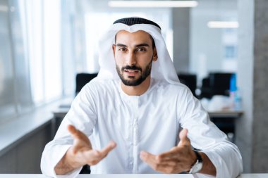 Dubai 'deki ofisinde çalışan yakışıklı bir adam. Geleneksel emirlik beyaz elbiseli başarılı bir iş adamının portreleri. Ortadoğu kültürleri, yaşam tarzı ve meslekleri hakkında kavram