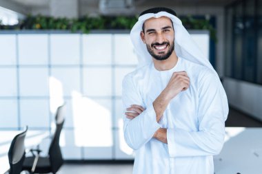 Dubai 'deki ofisinde çalışan yakışıklı bir adam. Geleneksel emirlik beyaz elbiseli başarılı bir iş adamının portreleri. Ortadoğu kültürleri, yaşam tarzı ve meslekleri hakkında kavram
