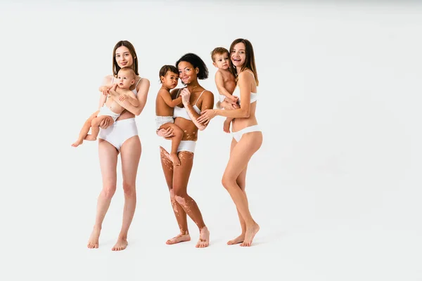 在有色人种背景下养育孩子的多民族快乐妇女 穿着内衣照顾小儿子的年轻妇女 体形阳性和体格接纳的概念 — 图库照片