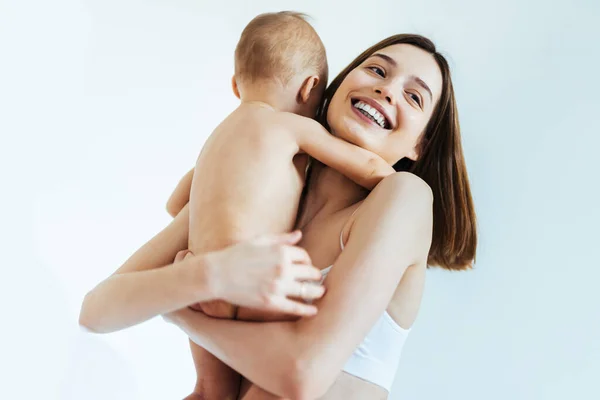 Gelukkige Vrouw Houdt Haar Baby Gekleurde Achtergrond Jonge Vrouw Draagt — Stockfoto