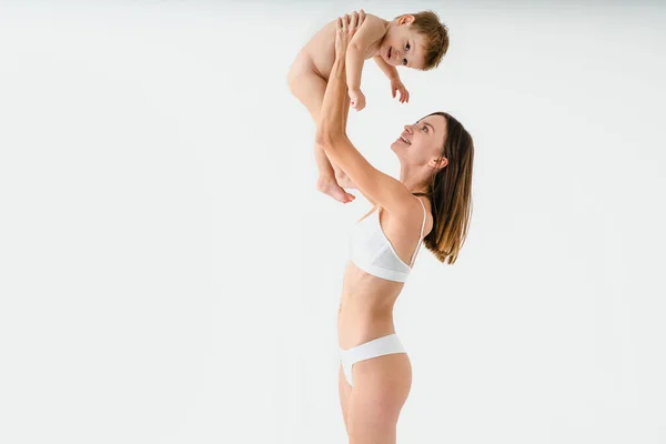 Gelukkige Vrouw Houdt Haar Baby Gekleurde Achtergrond Jonge Vrouw Draagt — Stockfoto