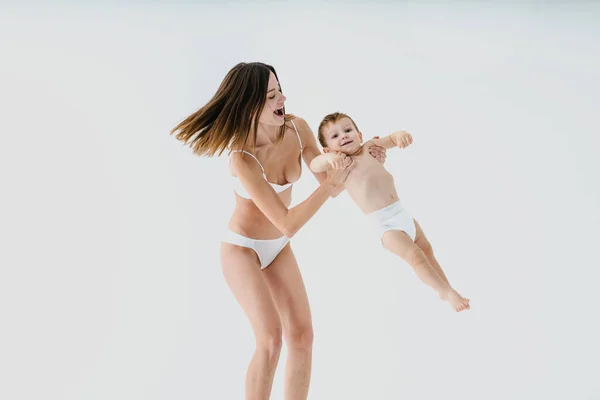 Gelukkige Vrouw Houdt Haar Baby Gekleurde Achtergrond Jonge Vrouw Draagt — Stockfoto