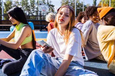 Açık havada kaynaşan ve şehir kaykay parkında toplanan havalı gençlerden oluşan çok kültürlü bir grup.