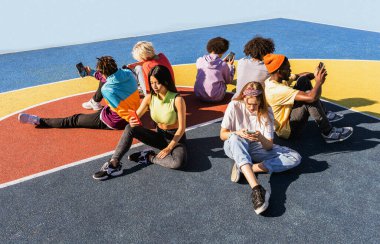 Multicultural group of young friends bonding outdoors and having fun - Stylish cool teens gathering at urban skate park clipart