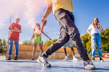 Açık havada kaynaşan ve şehir kaykay parkında toplanan havalı gençlerden oluşan çok kültürlü bir grup.
