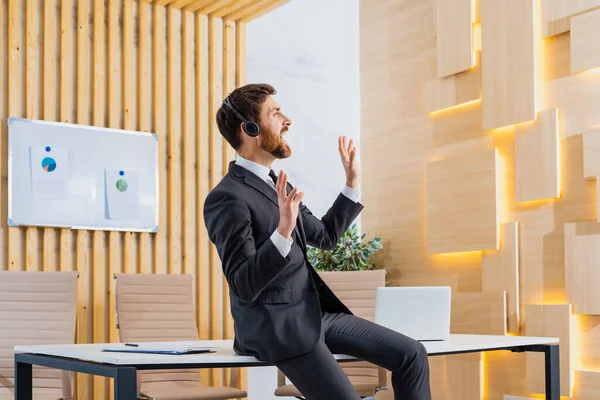 仕事でリラックスしたエレガントなスーツを着たビジネスマン イヤホンで音楽を聴く大人の男 ビジネスと技術に関する概念 — ストック写真