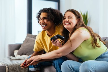 Modern, çok ırklı, klişe olmayan çift evde video oyunları oynuyor. Birlikte yaşayan basmakalıp erkek arkadaş ve kız arkadaş değil. Gerçek aşk kavramları