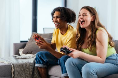 Modern, çok ırklı, klişe olmayan çift evde video oyunları oynuyor. Birlikte yaşayan basmakalıp erkek arkadaş ve kız arkadaş değil. Gerçek aşk kavramları