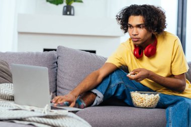 Evde bilgisayarının başında rahat bir şekilde çalışan genç bir çocuk. Gençler dijital sanat ve NFT çevrimiçi seçiyor