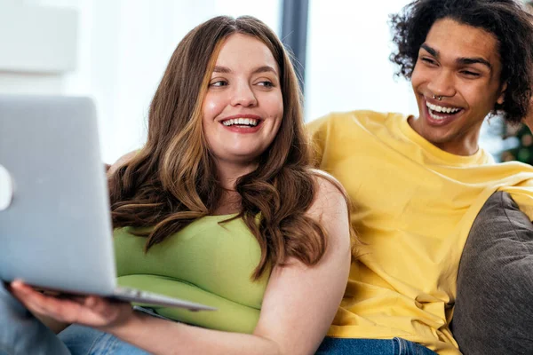 現代の多民族のステレオタイプではないカップルがコンピュータでシリーズを見ています ステレオタイプの彼氏と彼女は一緒に住んでいません 真の愛の概念 — ストック写真